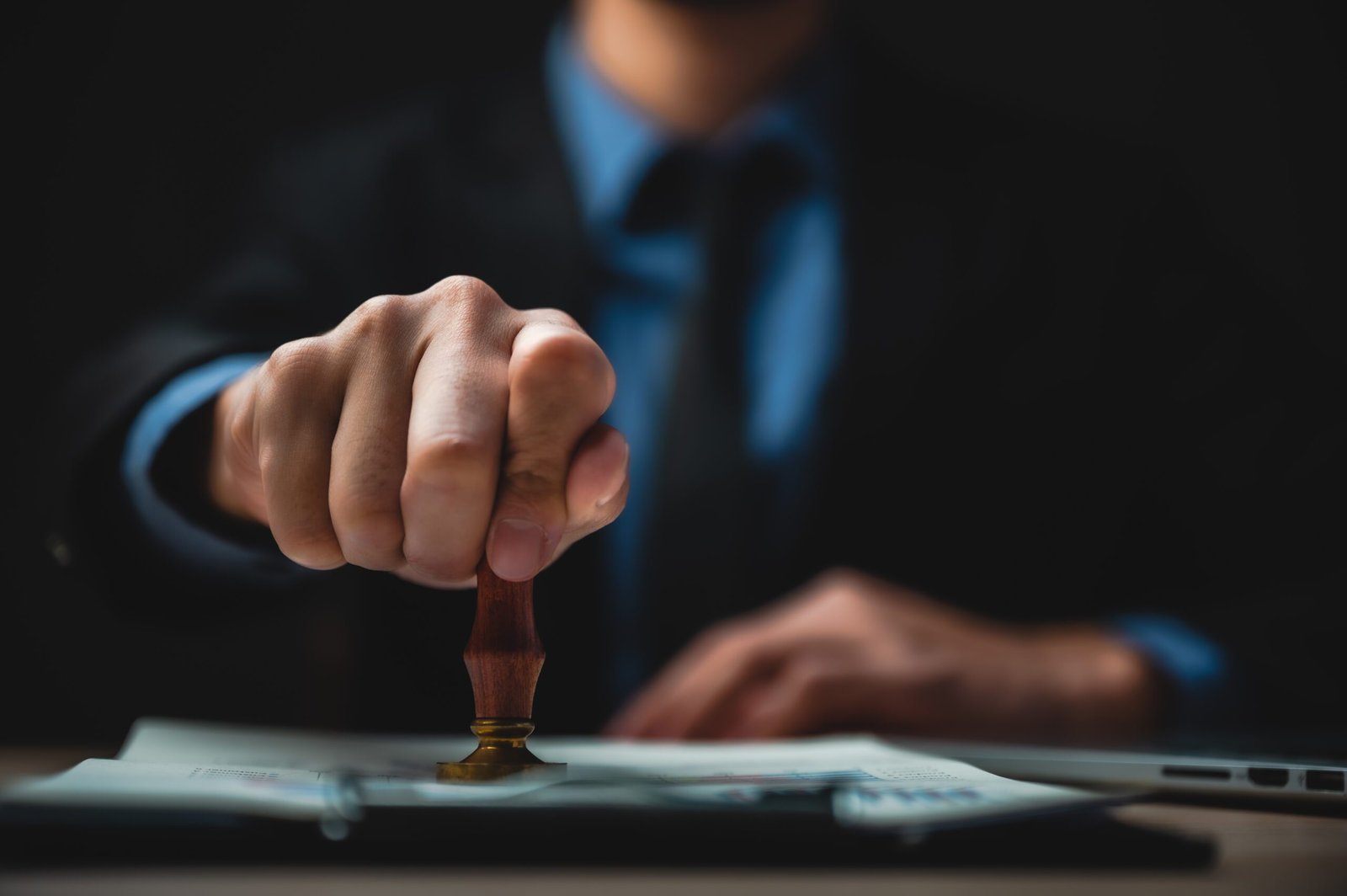  close-up-person-s-hand-stamping-with-approved-stamp-document-desk-scaled